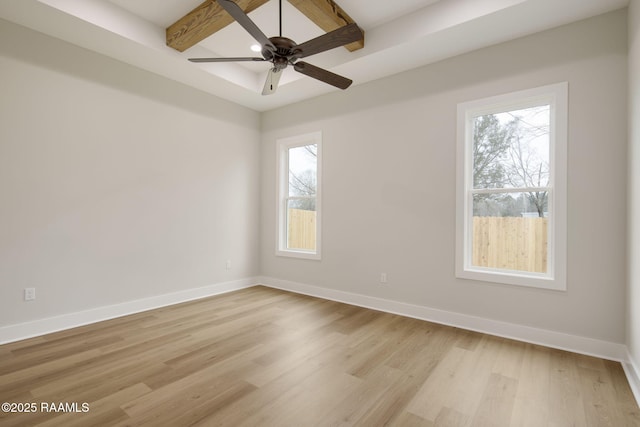 empty room featuring beam ceiling, ceiling fan, and light wood-type flooring