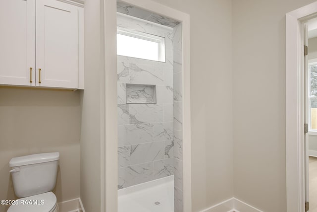 bathroom featuring toilet and tiled shower