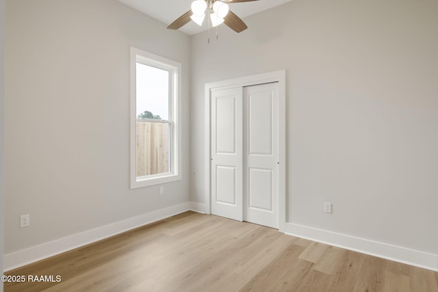 unfurnished bedroom featuring ceiling fan, light wood-type flooring, and a closet