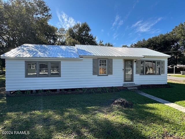 1722 Michael St, Abbeville, LA 70510 - view of front of house featuring entry steps, a front yard, and a metal roof