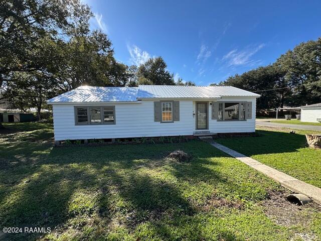 1722 Michael St, Abbeville, LA 70510 - view of front of property with a front lawn, a metal roof, and entry steps