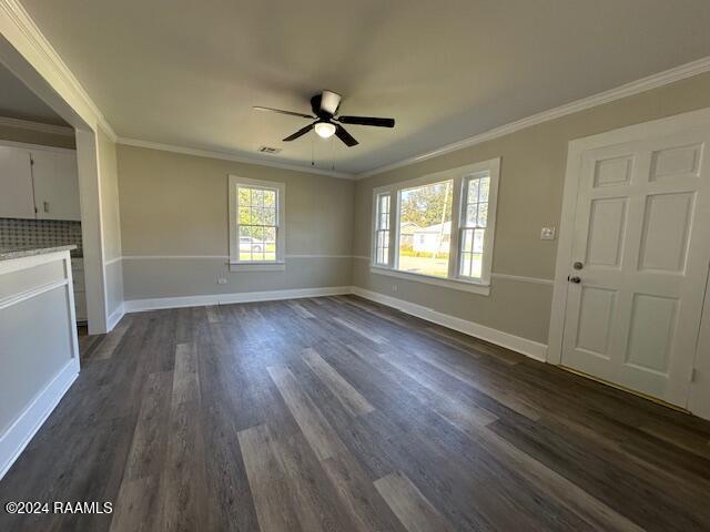 unfurnished living room with ceiling fan, dark hardwood / wood-style floors, and ornamental molding