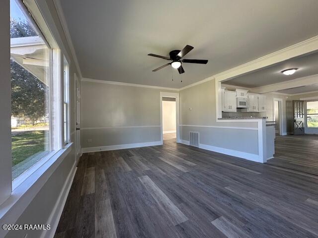 1722 Michael St, Abbeville, LA 70510 - unfurnished living room featuring dark wood finished floors, ceiling fan, and ornamental molding