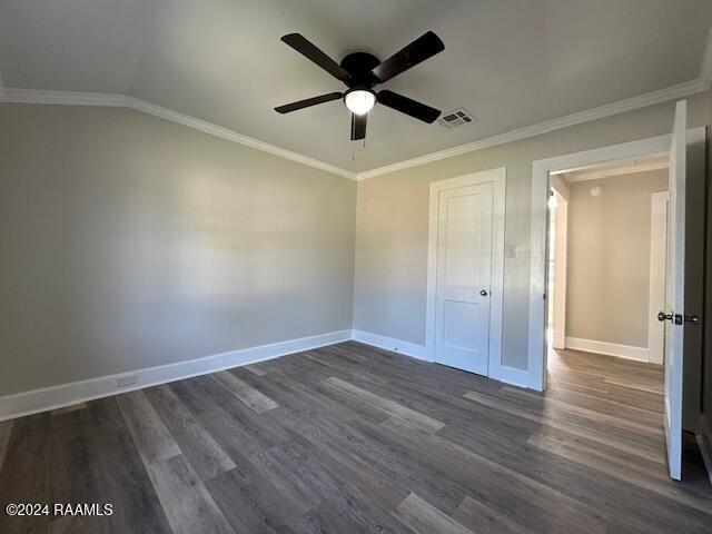 unfurnished bedroom with dark hardwood / wood-style flooring, ceiling fan, and crown molding