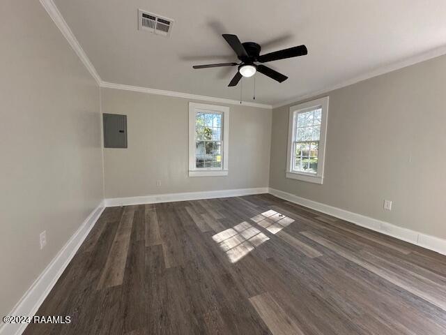 spare room with ceiling fan, crown molding, dark wood-type flooring, and electric panel