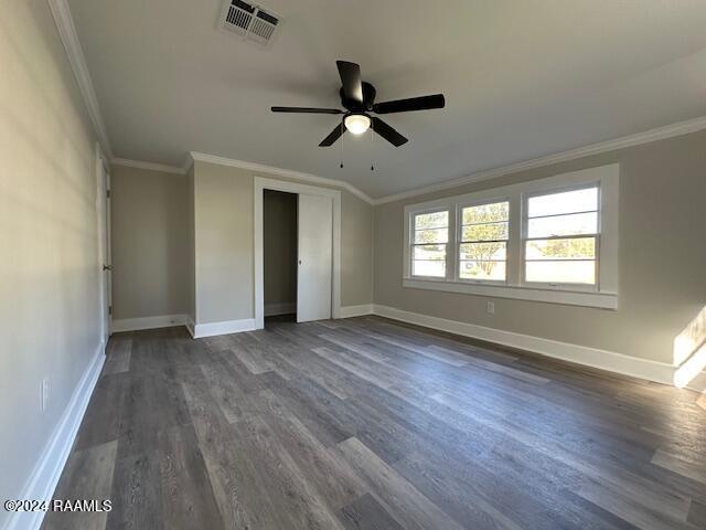 unfurnished bedroom with ceiling fan, dark hardwood / wood-style floors, and ornamental molding