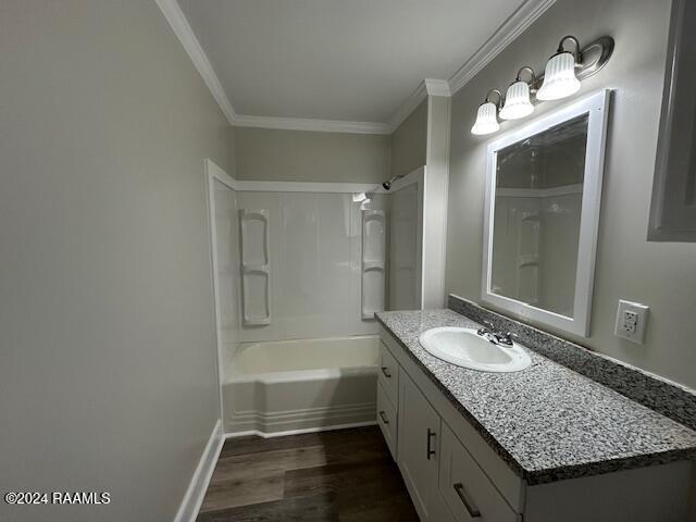 bathroom with bathtub / shower combination, vanity, hardwood / wood-style flooring, and crown molding