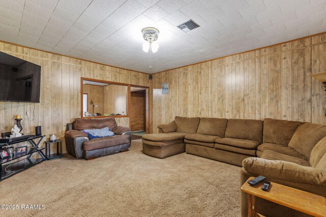 carpeted living room with wooden walls