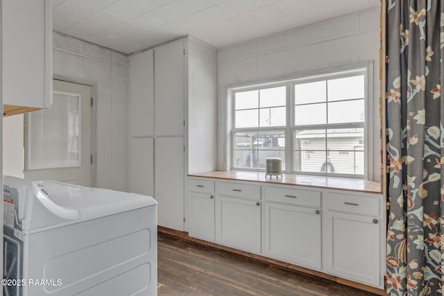 kitchen with washer / dryer, dark hardwood / wood-style floors, and white cabinetry