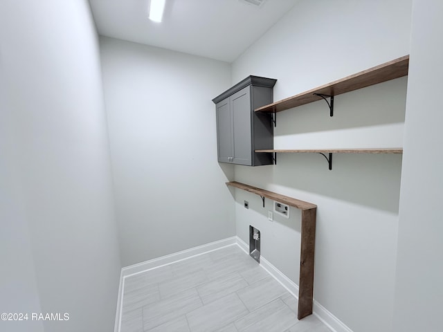 washroom featuring washer hookup, electric dryer hookup, and cabinets