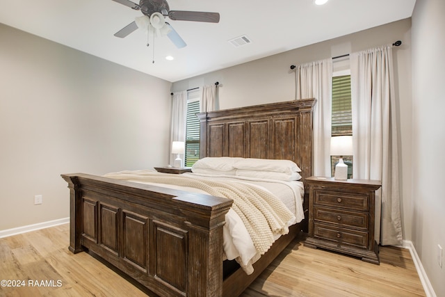 bedroom featuring light wood-type flooring, multiple windows, and ceiling fan