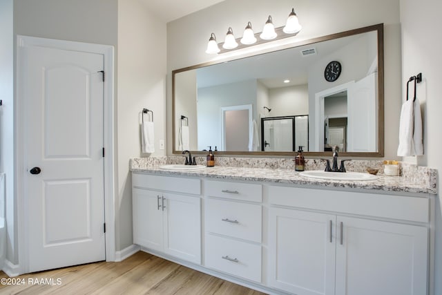 bathroom featuring vanity, wood-type flooring, and walk in shower