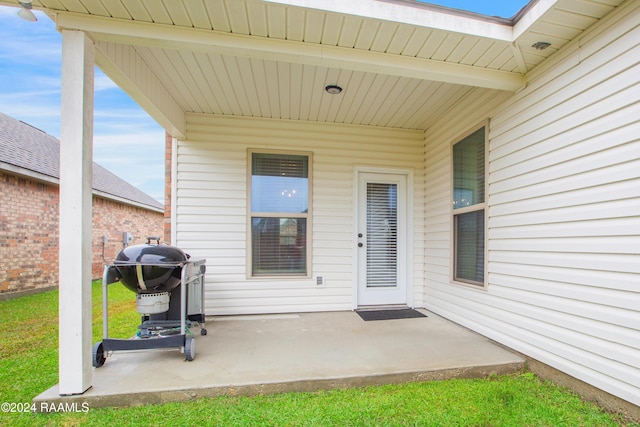 view of exterior entry with a patio area