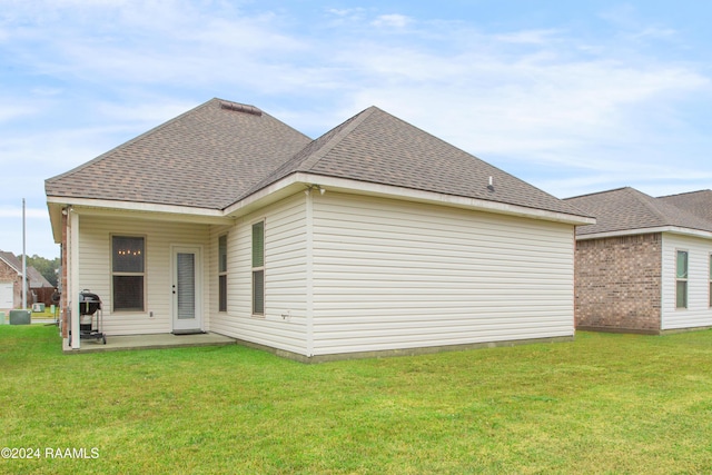 back of property featuring a patio area and a yard