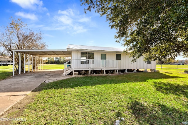 view of front of house with covered porch, a front yard, and a carport