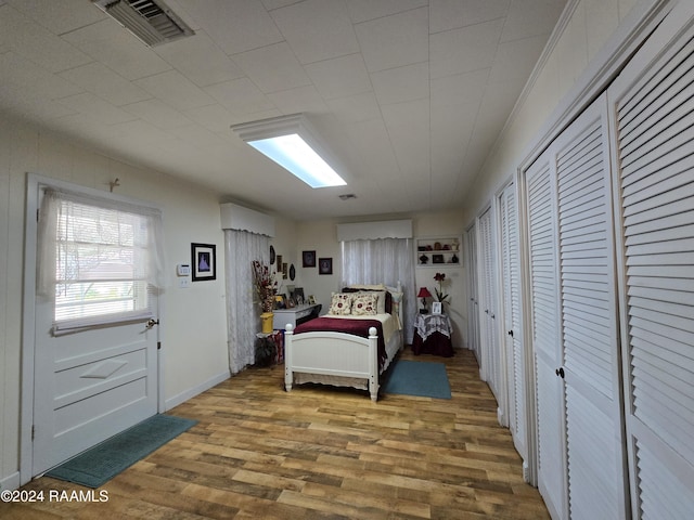 bedroom featuring hardwood / wood-style floors and two closets