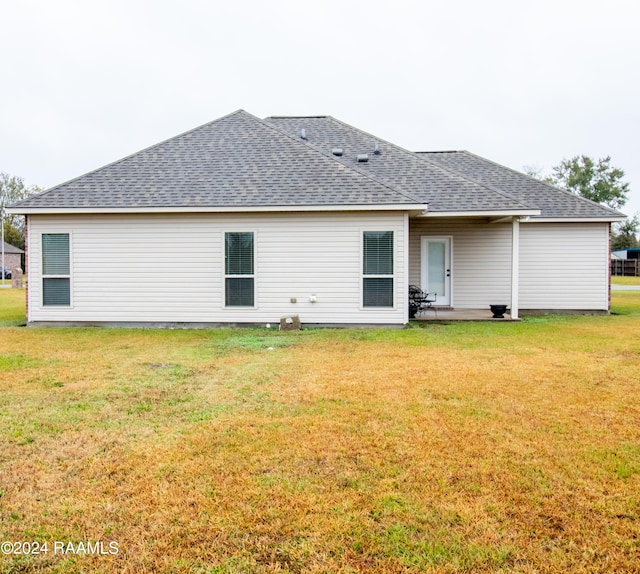 back of house featuring a lawn and a patio