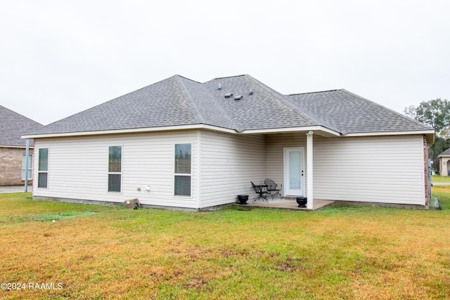 rear view of house featuring a patio and a lawn