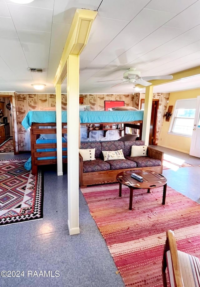 bedroom featuring wood walls and ceiling fan