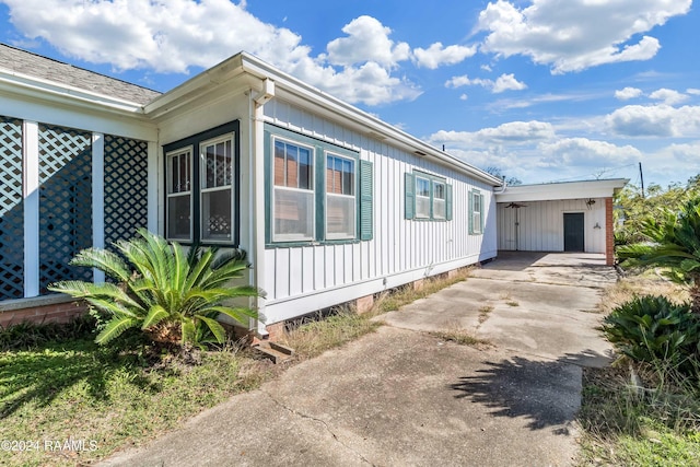 view of side of property featuring board and batten siding and driveway