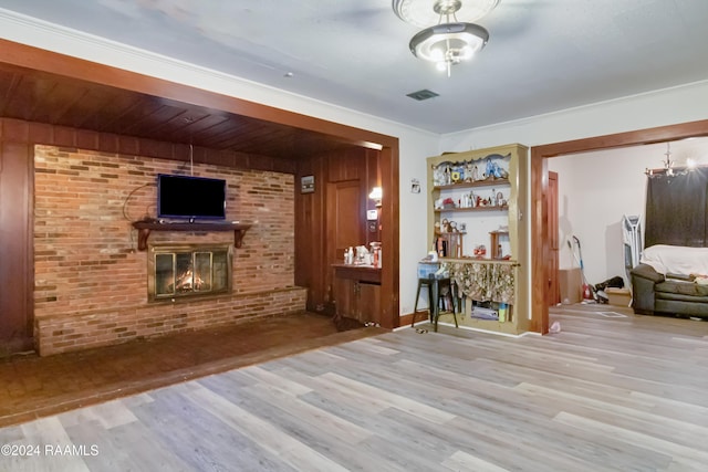 interior space featuring visible vents, a brick fireplace, brick wall, a dry bar, and wood finished floors