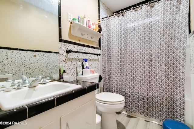 full bathroom with toilet, tile walls, and vanity