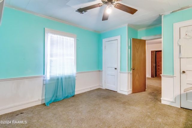 unfurnished bedroom with ceiling fan, carpet flooring, and ornamental molding