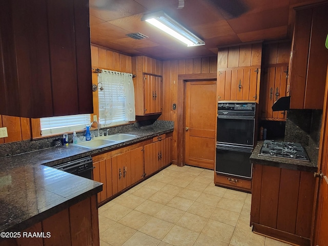 kitchen with dark countertops, stainless steel gas stovetop, and brown cabinetry