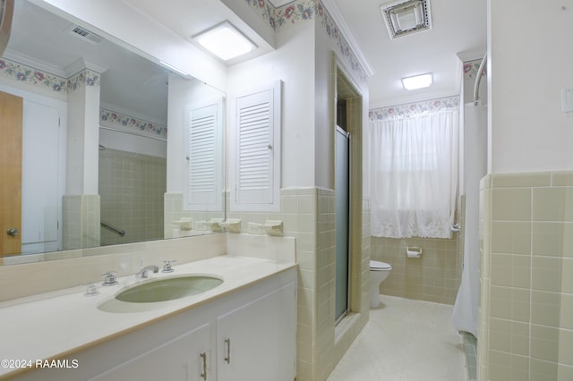 bathroom with vanity, crown molding, toilet, tile walls, and an enclosed shower