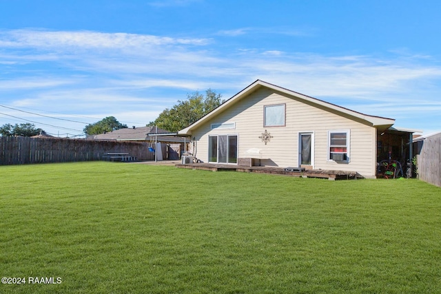 rear view of property featuring a yard and cooling unit