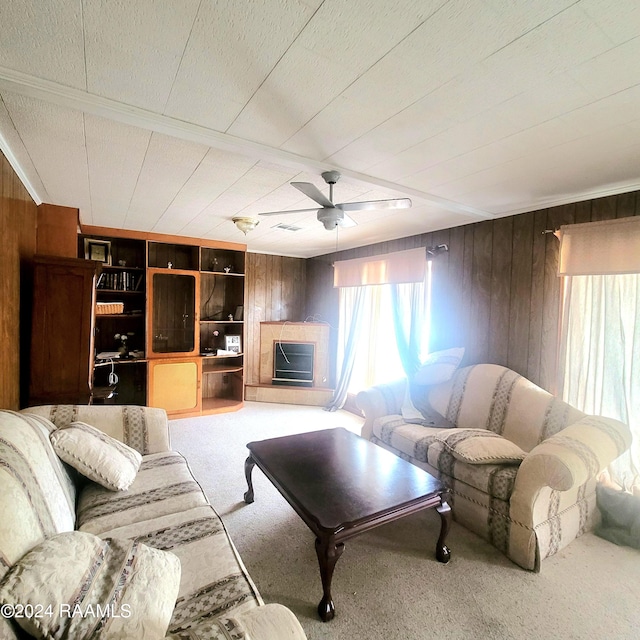 carpeted living room featuring ceiling fan, wood walls, and a textured ceiling