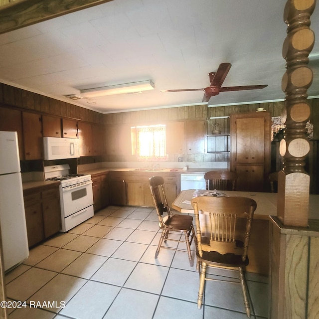 kitchen featuring ceiling fan, crown molding, white appliances, wooden walls, and light tile patterned floors