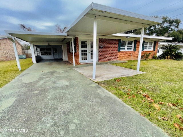 view of front of property with central air condition unit, a front lawn, and a carport