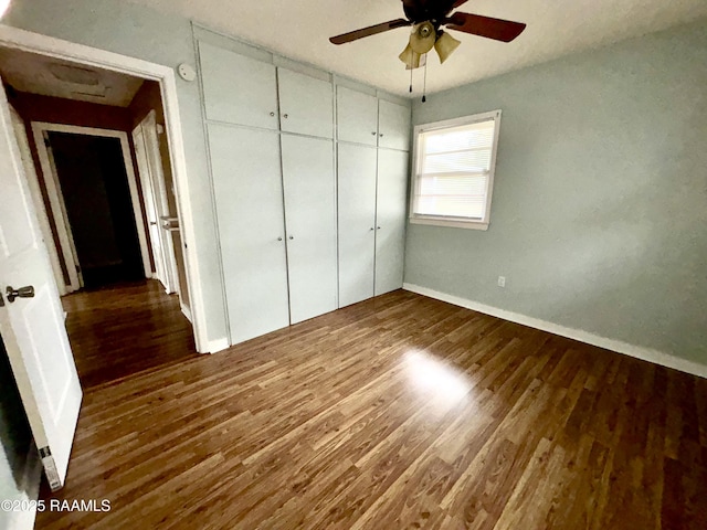 unfurnished bedroom with ceiling fan, a closet, and dark hardwood / wood-style flooring