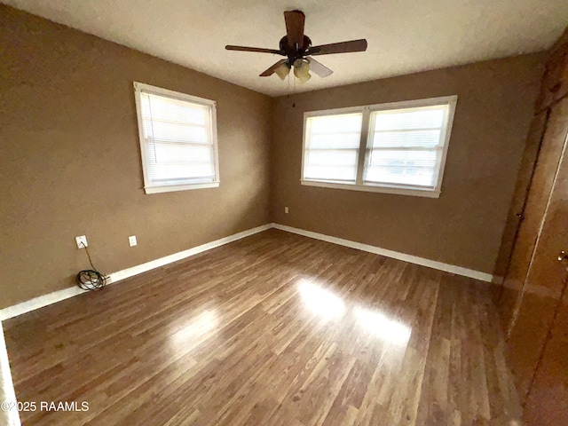 unfurnished room featuring ceiling fan, a healthy amount of sunlight, and hardwood / wood-style floors