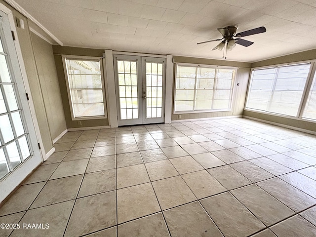 unfurnished sunroom featuring ceiling fan, french doors, and a wealth of natural light