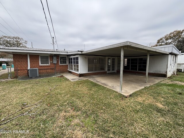 back of property with a patio area and a yard