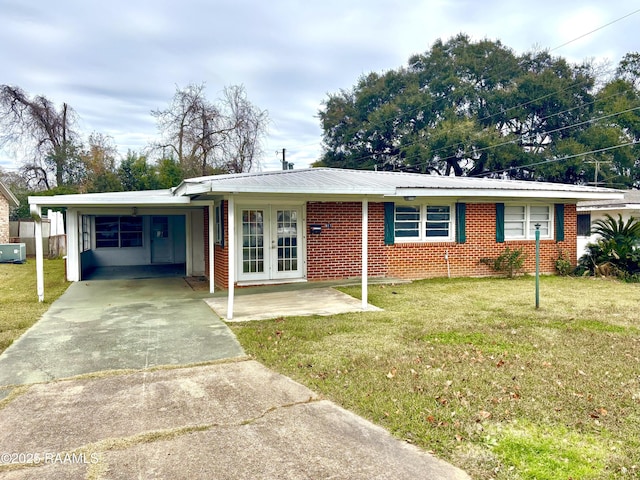 single story home with a front lawn, a carport, and french doors