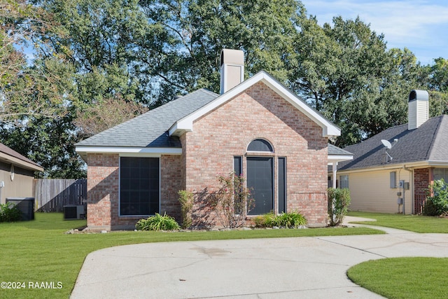 view of front of house with central air condition unit and a front yard