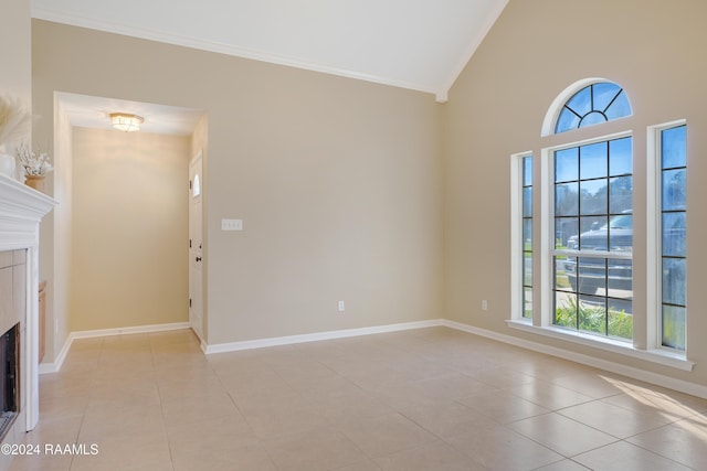 unfurnished living room with crown molding, plenty of natural light, light tile patterned flooring, and high vaulted ceiling