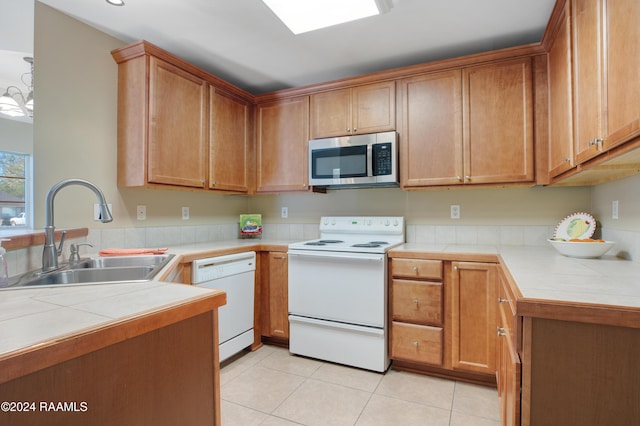 kitchen featuring tile countertops, white appliances, sink, and light tile patterned floors