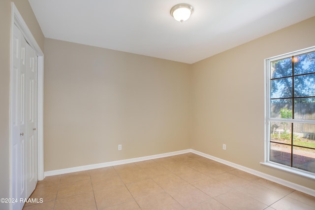 spare room featuring plenty of natural light and light tile patterned floors