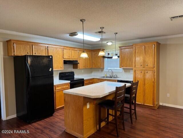 kitchen featuring sink, dark wood-type flooring, pendant lighting, a kitchen island, and black appliances