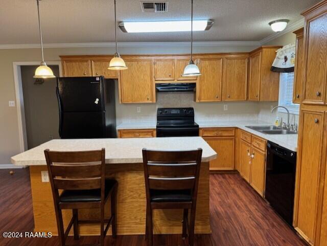 kitchen with a center island, black appliances, sink, dark hardwood / wood-style floors, and decorative light fixtures