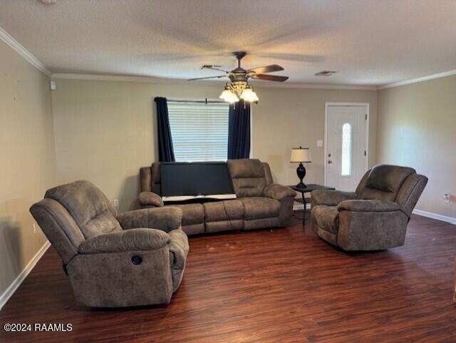 living room with ceiling fan, dark hardwood / wood-style flooring, and crown molding