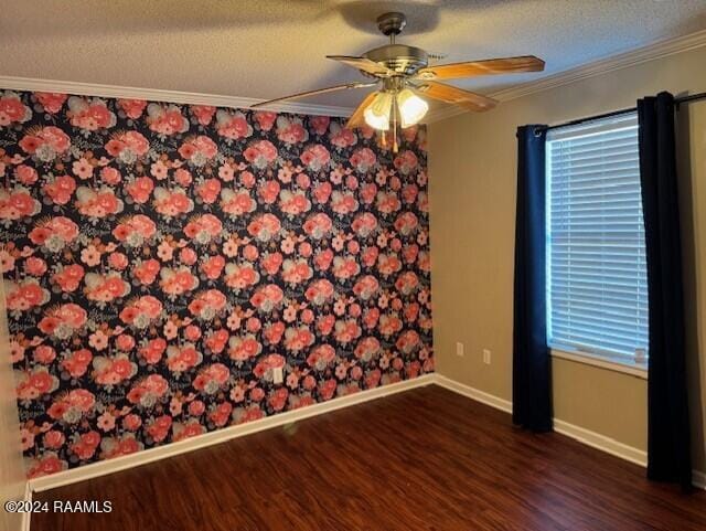 spare room with a textured ceiling, ceiling fan, dark hardwood / wood-style flooring, and crown molding