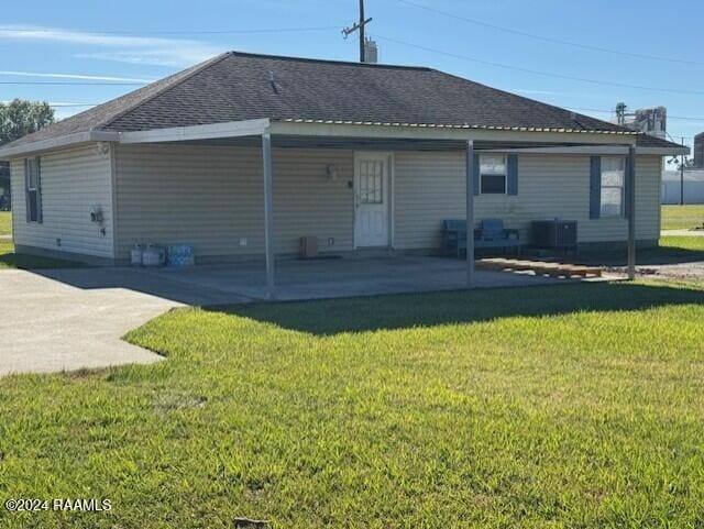 rear view of property featuring a patio and a lawn