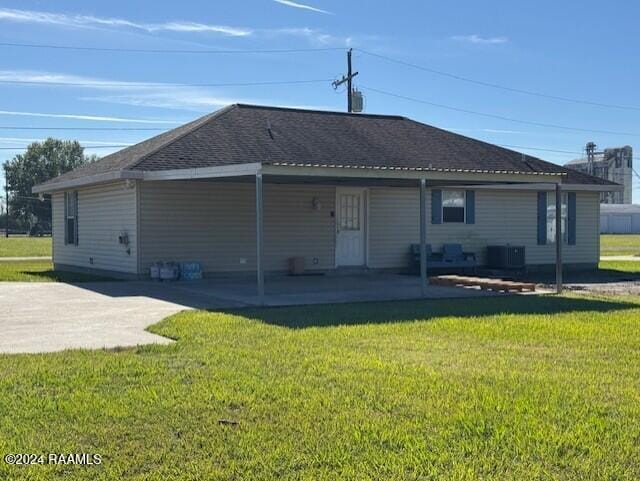 back of house with a lawn and a patio