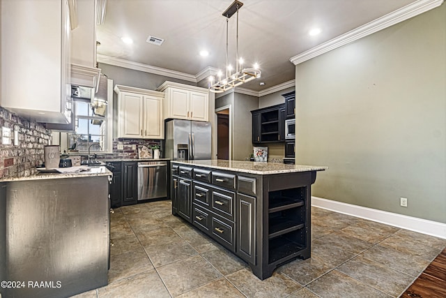 kitchen with a center island, crown molding, appliances with stainless steel finishes, and a chandelier