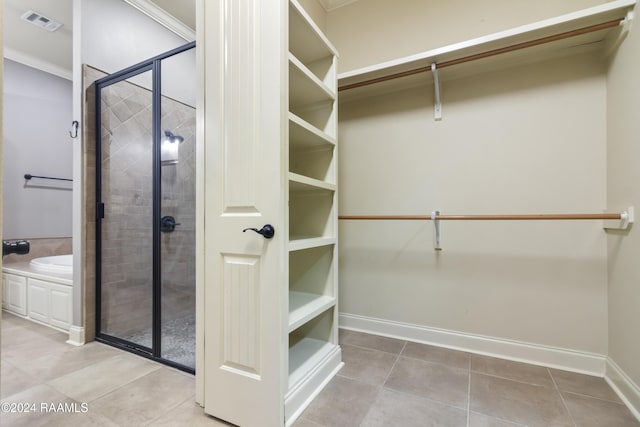 walk in closet with light tile patterned floors